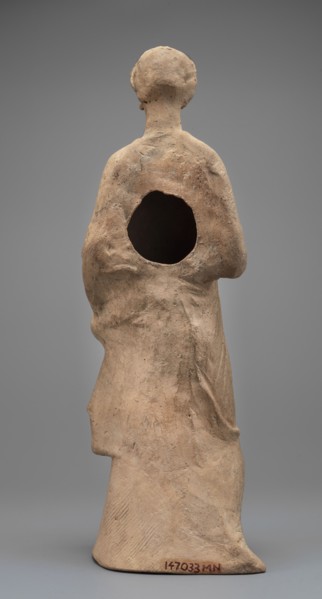 Female Figurine. Standing woman dressed in a long robe, slightly pleated and belted high under the