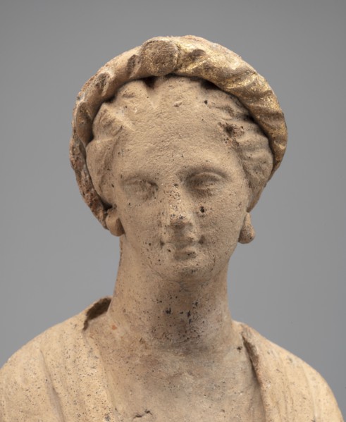 Female Figurine. Standing woman dressed in a long robe, slightly pleated and belted high under the