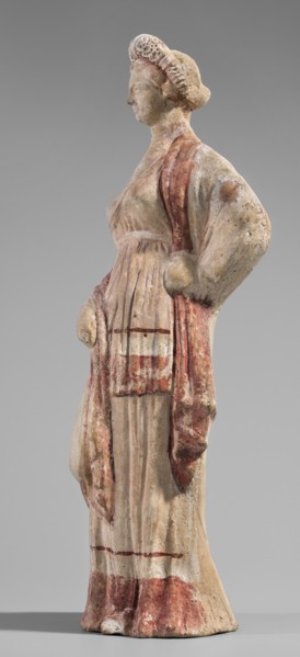 Figurine of a maenad. A young woman standing in a wreath tied with a ribbon is dressed in a chiton