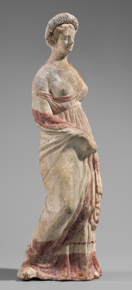 Figurine of a maenad. A young woman standing in a wreath tied with a ribbon is dressed in a chiton