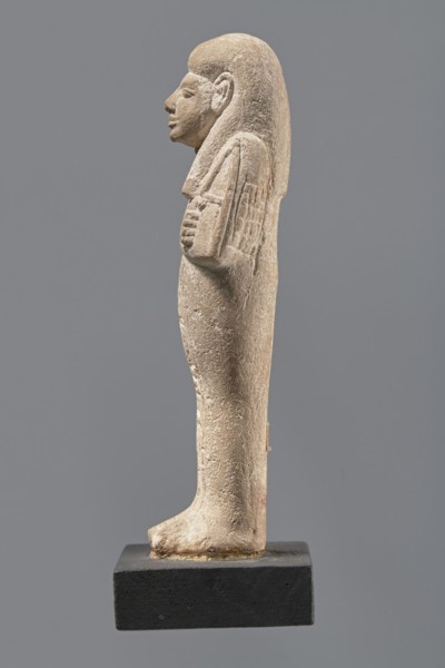 Ushabti, Mummy-shaped figurine made of limestone. Arms crossed on the chest, the right over the