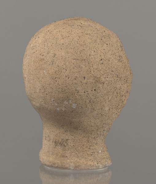 Votive head, Head of a young man covered with a shawl, from under which hair emerges in the form of