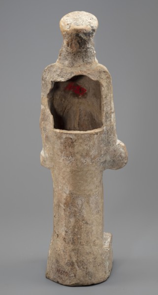 Female terracotta figurine of a standing woman positioned frontally on a quadrangular base. The
