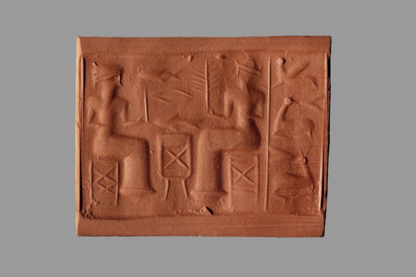 Cylinder seal with a banquet scene, unknown Assyrian workshop. The cylinder's surface is engraved