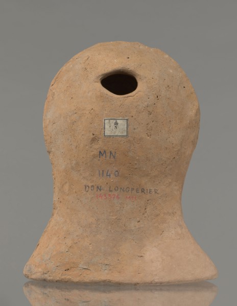 Votive female head, Female head wearing a wreath, from under which lush locks of hair curl down the
