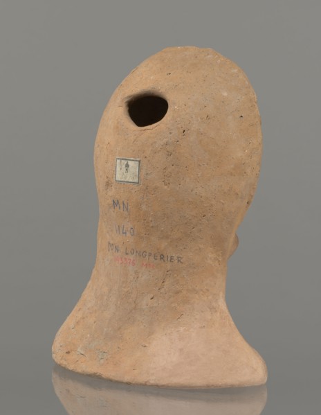 Votive female head, female head wearing a wreath, from under which lush locks of hair curl down the