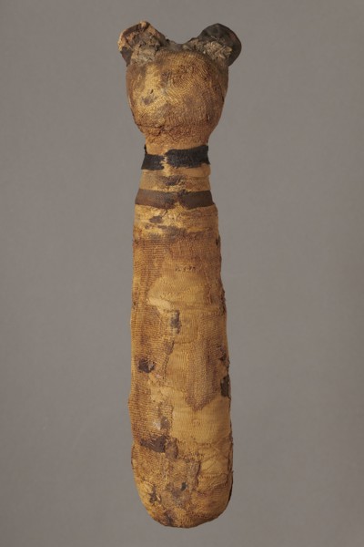 Cat mummy decorated with a meander made of white and brown bandages. Cat mummy, linen fabrics;