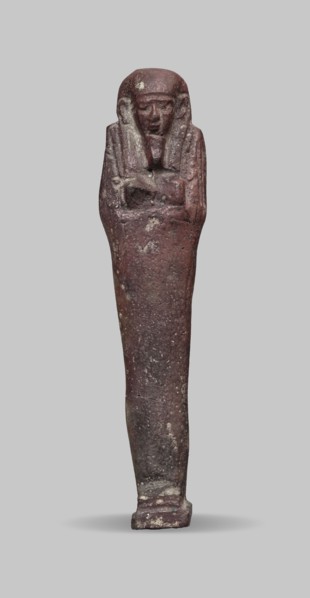 Ushabti, A shabti figurine dressed in a shroud stands on a base. On the head is a smooth wig