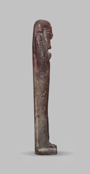 Ushabti, A shabti figurine dressed in a shroud stands on a base. On the head is a smooth wig,