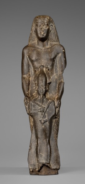Figurine of a priest with a statuette of the god Osiris. The priest is shown standing, holding in
