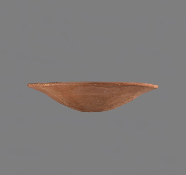 Bowl. Low bowl with irregular, strongly flaring walls and a rounded bottom. Rounded rim, slightly