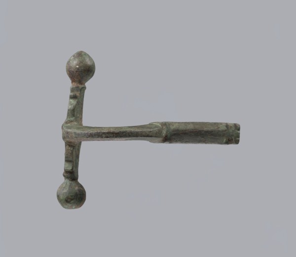 Onion-shaped fibula, Italy. Bronze fibula with a hinged structure featuring an arched ring made