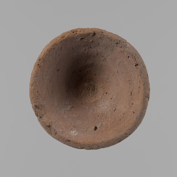 Bowl, probably votive, conical shape with a flat bottom. Irregular walls; straight, slightly