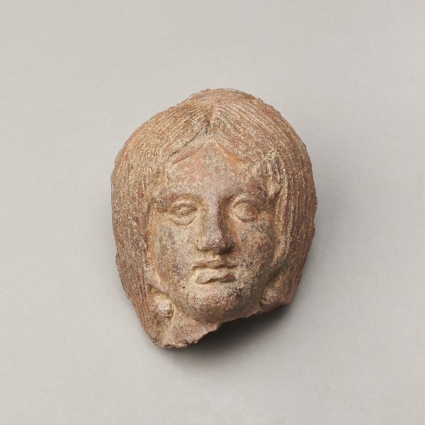 Female votive head, Female head with long, straight hair falling to the shoulders. Neck partially