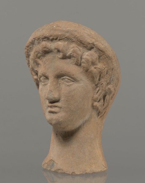 Female votive head, Female head in a wreath, slightly tilted to the right shoulder. Under the