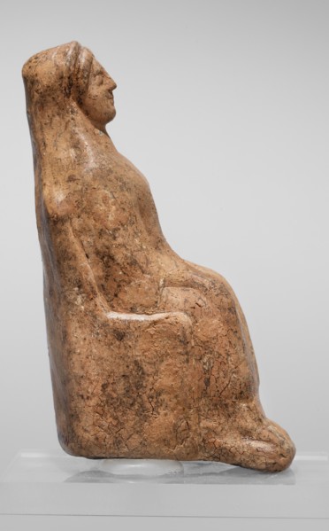 Figurine of a seated woman. Figurine of a woman sitting on a throne with her hands placed on her