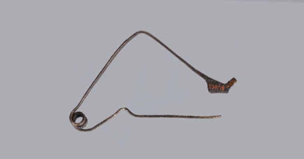 Bronze Etruscan fibula with a bent ring made of flatly beaten wire, passing in a three-turn spiral