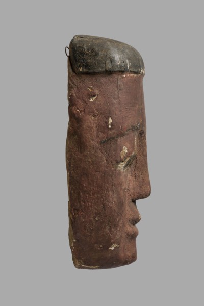 Sarcophagus mask with a flat fragment of a wig above the forehead. Elongated face, painted brown,