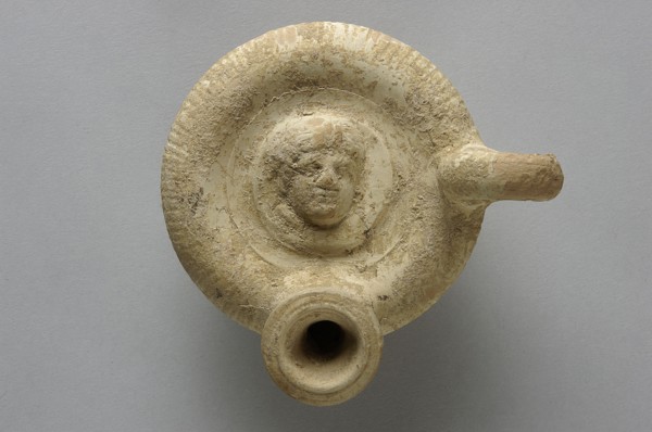 Guttus, top decorated with a plastic medallion with the image of a woman's head shown