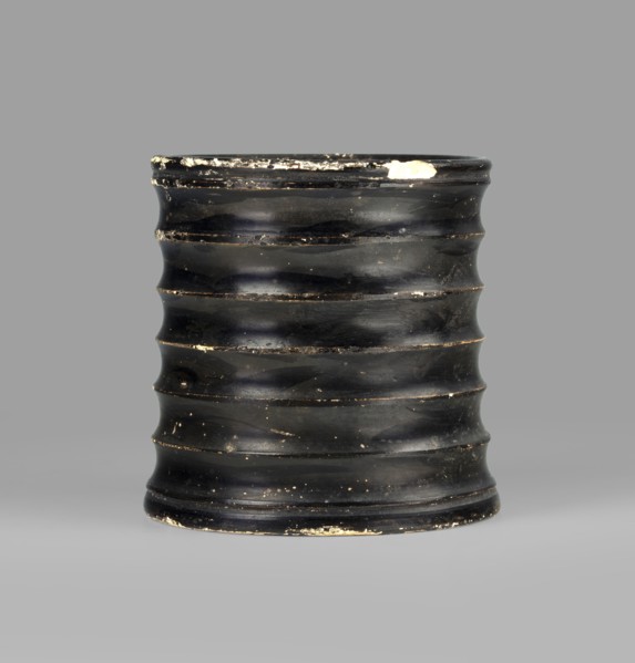 Dice cup. Small cup with a flat slightly concave bottom; slightly tapered walls and distinct rim.