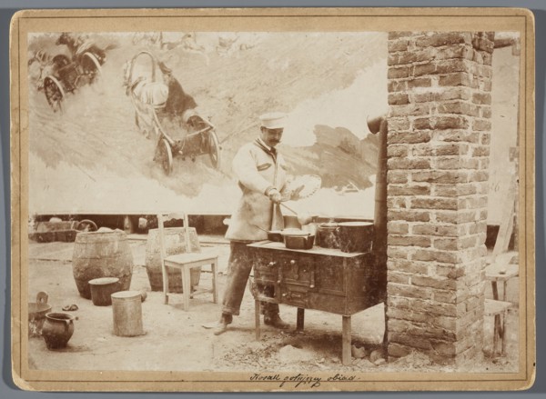 Painting the Raclawice Panorama: Wojciech Kossak with a palette in his hand cooking dinner, in a