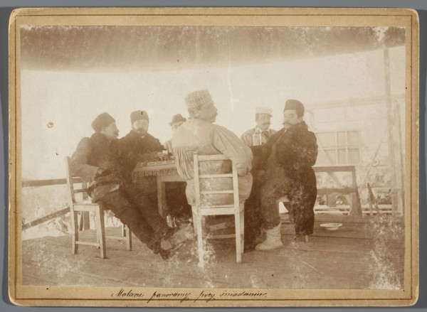 Six painters seated at a table on the central platform in the rotunda painting the Raclawice