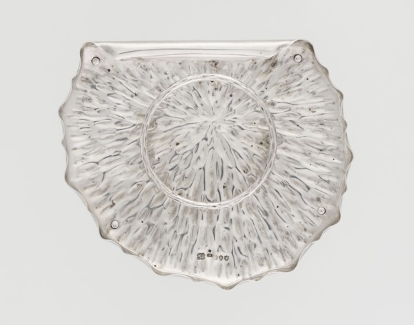 Jam or honey container stand in the shape of a stylized leaf, rolled up on one side, with wavy