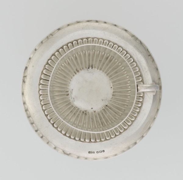 Hemispherical cup and saucer, decorated with radiating curls to half the cup's height, with a