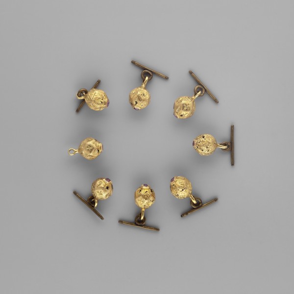 Buttons for a zupan with clasps. Nearly spherical, polygonal buttons with engraved four-leaf