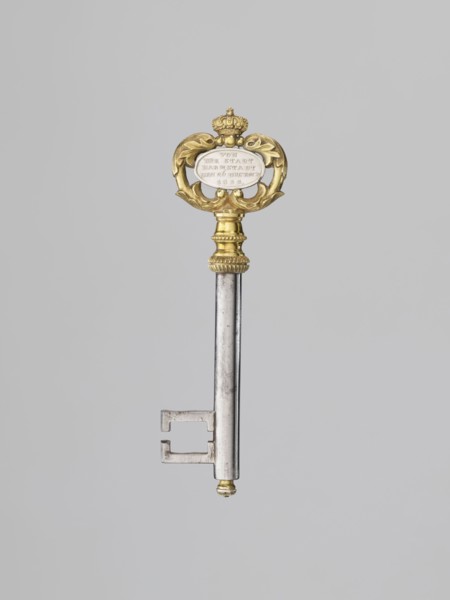 Souvenir key, steel, with a full shank and a simple feather in the form of two square brackets.