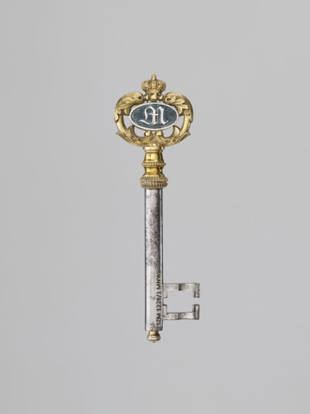 Souvenir key, steel, with a full shank and a simple feather in the form of two square brackets.