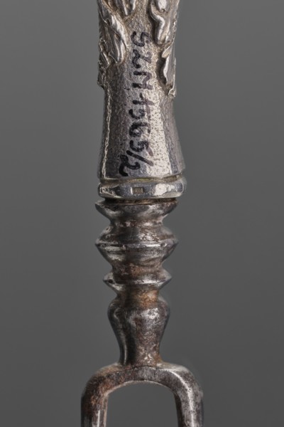 Fork. Two-pronged steel fork with a silver handle shaped as a full-plastic female herm, decorated