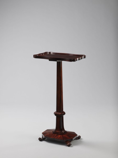 Pedestal table with a rectangular top with a wavy-cut edge and a low wooden gallery, supported by
