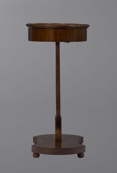 Oval display table with a lyre-shaped base mounted on a platform with a concave-convex outline,