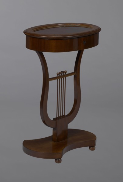 Oval display table with lyre-shaped base mounted on a platform with a concave-convex outline,