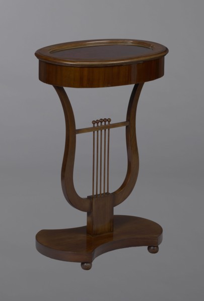 Oval display table with a lyre-shaped base mounted on a platform with a concave-convex outline,