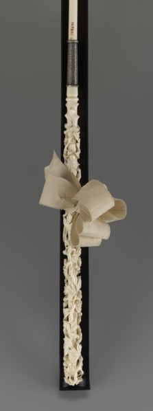 Women's umbrella made of white lace. Its canopy is trimmed with cream silk at the bottom, which