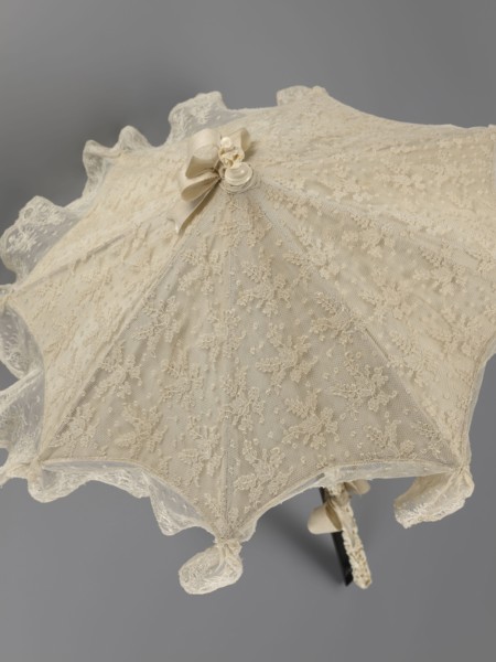 Umbrella. Women's umbrella made of white lace with a canopy trimmed with cream silk at the bottom