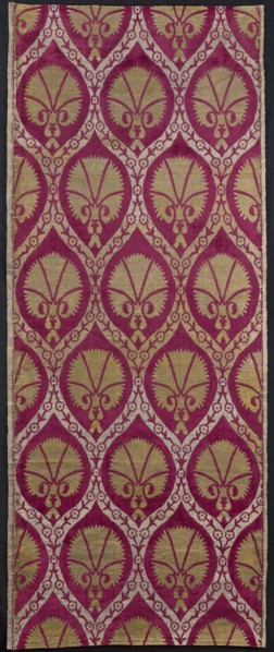 Fabric with a motif of pointed ovals formed from wide ribbons decorated with floral tendrils.