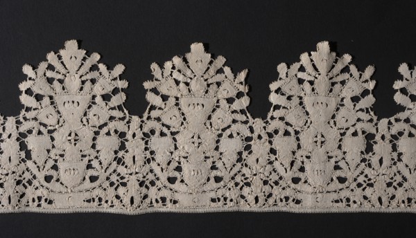 Lace fragment, Floral ornaments. Lace, lower edge serrated. In each oval there is a vase of