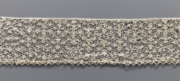 Lace fragment, Lace with a fine floral pattern. de brides background with picots. Lower edge with