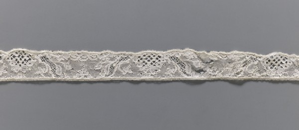 Lace fragment, Floral ornaments. Malines lace. Pattern with motifs of winding ribbons, flowers, and