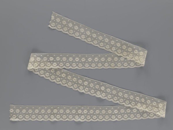 Lace fragment, tied in the form of a belt with one-sided arched serrations. Regular ornament: