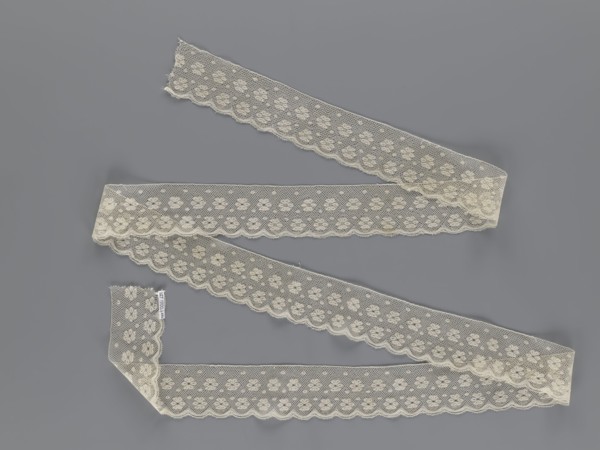 Lace fragment, tied in the form of a belt with one-sided arched serrations. Regular ornament: