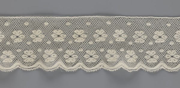 Lace fragment, tied in the form of a belt with one-sided arched serrations. Regular ornament: