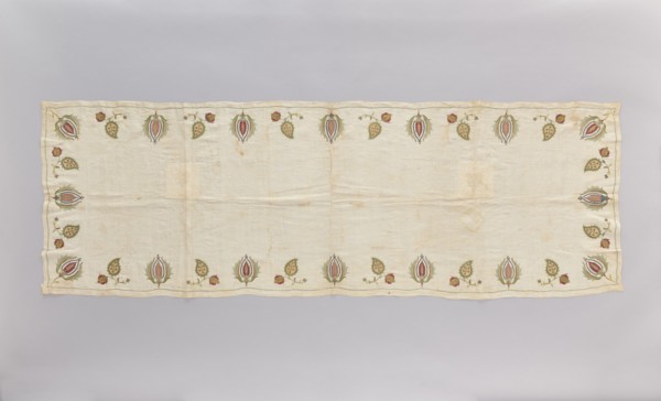 Church napkin made of thin white linen batiste edged with multicoloured embroidery. Ornament
