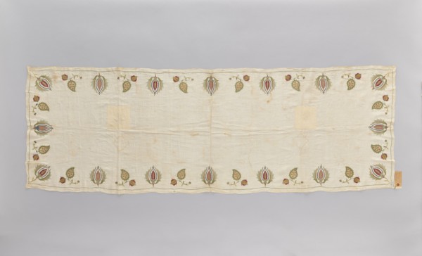 Church napkin made of thin white linen batiste edged with multicoloured embroidery. Ornament