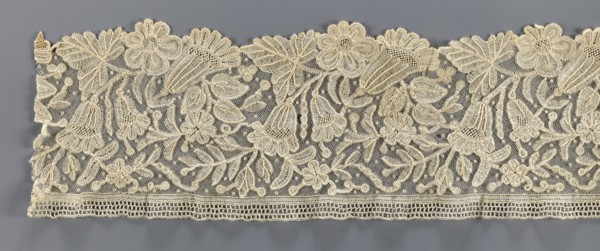 Lace fragment, bobbin lace with relief edges made with a needle on a tulle background, featuring a