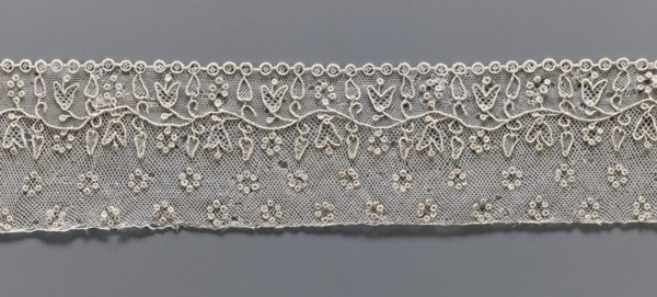 Lace fragment, needle Alençon lace; a flower branch parallel to the edge. Above the branch, in the