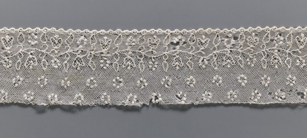 Lace fragment, needle lace Alençon lace, A flower branch parallel to the edge. Above the branch, in